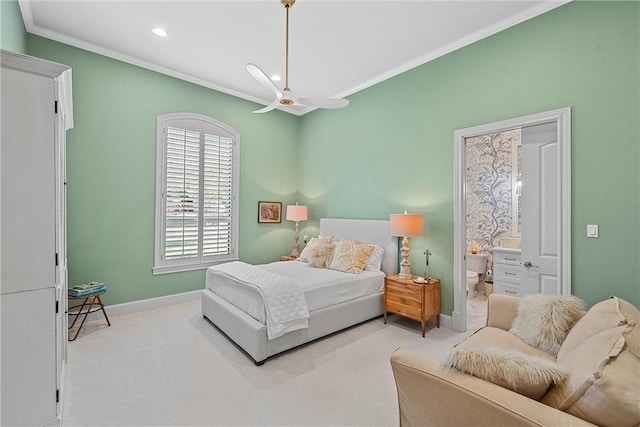 carpeted bedroom featuring ceiling fan, ensuite bathroom, and crown molding