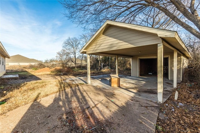 view of patio with a garage, a carport, and an outdoor structure