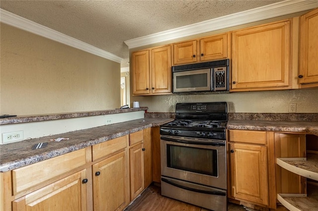 kitchen with a textured ceiling, ornamental molding, and stainless steel appliances