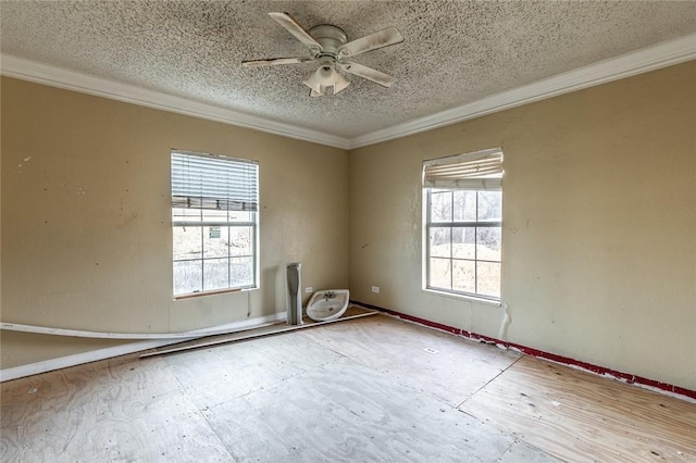 spare room with ceiling fan, plenty of natural light, crown molding, and a textured ceiling