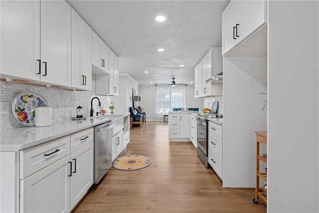 kitchen featuring light stone countertops, white cabinetry, ceiling fan, stainless steel appliances, and light hardwood / wood-style floors