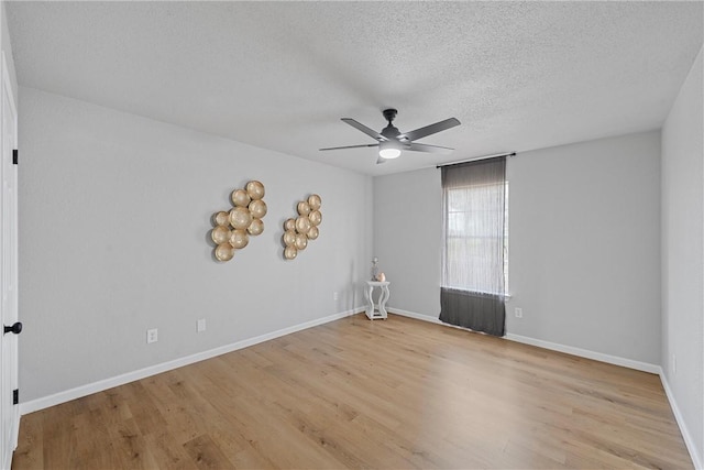 empty room featuring ceiling fan, light hardwood / wood-style flooring, a textured ceiling, and radiator heating unit