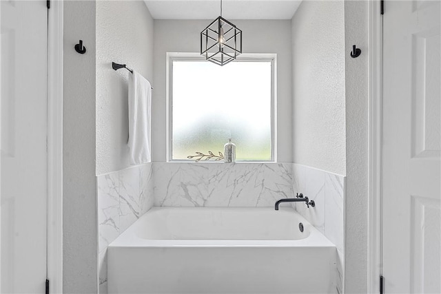 bathroom featuring a tub to relax in and a wealth of natural light