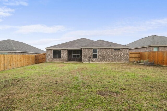 rear view of house featuring a yard