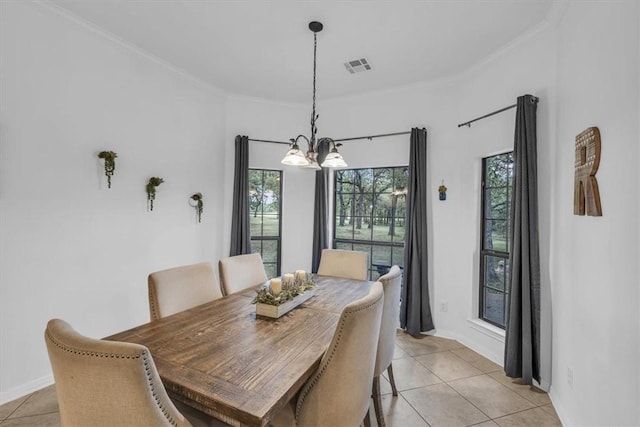 tiled dining area featuring ornamental molding and a chandelier