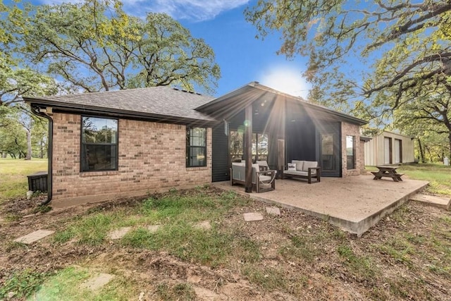 back of house featuring a patio, an outdoor hangout area, and a storage shed