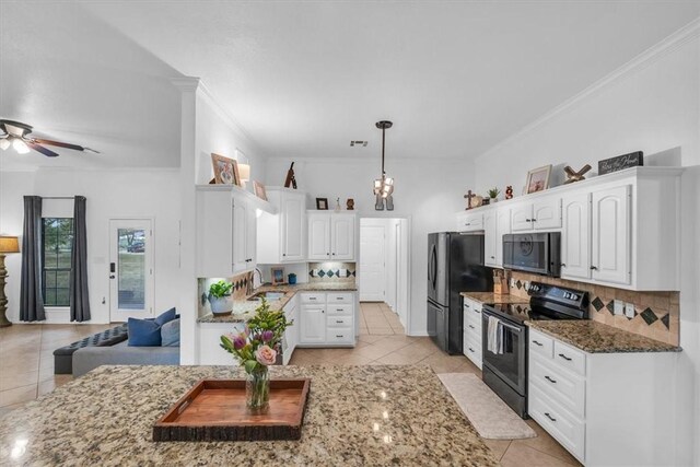 kitchen featuring decorative backsplash, black refrigerator, range with electric stovetop, and white cabinets