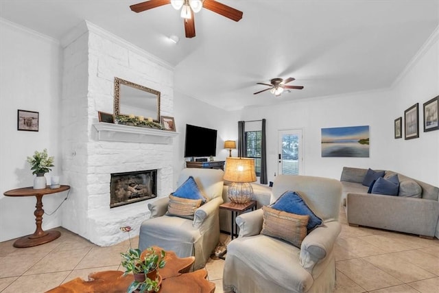 living room with ceiling fan, crown molding, a stone fireplace, and light tile patterned floors