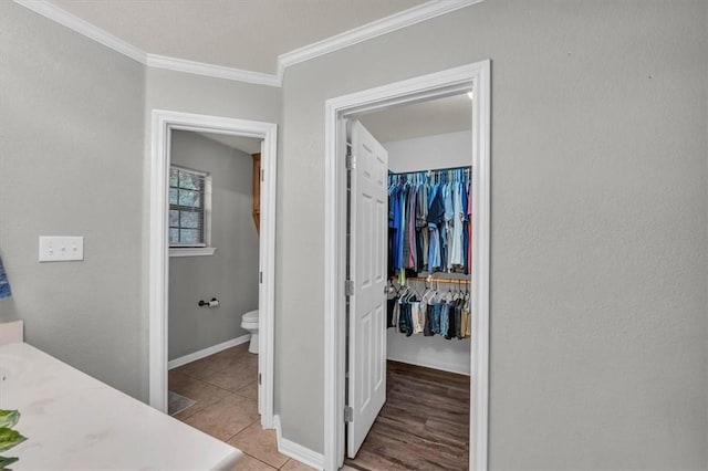 bathroom with toilet, vanity, tile patterned flooring, and ornamental molding