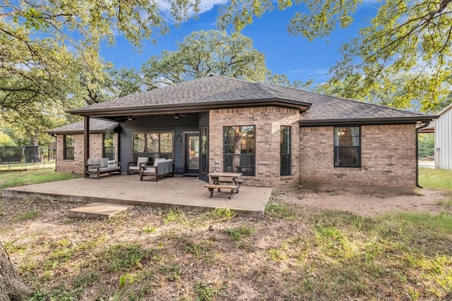 rear view of property featuring an outdoor living space and a patio