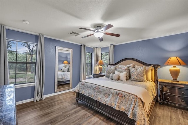 bedroom with ceiling fan, ornamental molding, and dark hardwood / wood-style floors