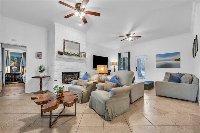 tiled living room featuring a wealth of natural light, ceiling fan, a stone fireplace, and ornamental molding