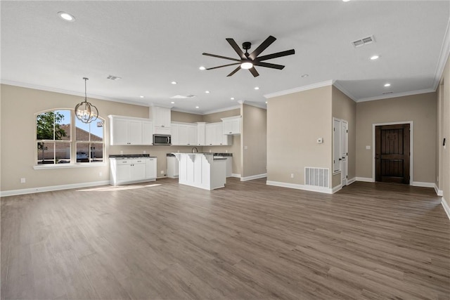 unfurnished living room with hardwood / wood-style floors, ceiling fan with notable chandelier, and crown molding