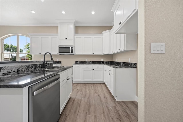 kitchen featuring white cabinets, stainless steel appliances, light hardwood / wood-style flooring, and sink