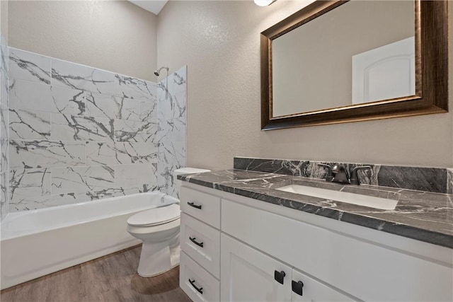 full bathroom with hardwood / wood-style flooring, toilet, vanity, and tub / shower combination