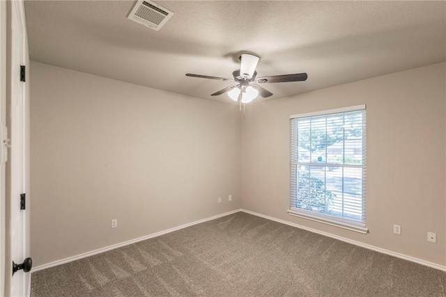 empty room with ceiling fan, carpet floors, and a textured ceiling