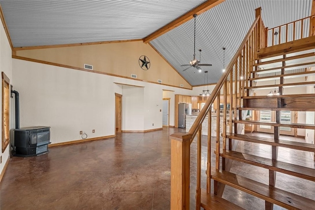 staircase featuring beamed ceiling, high vaulted ceiling, a wood stove, and ceiling fan