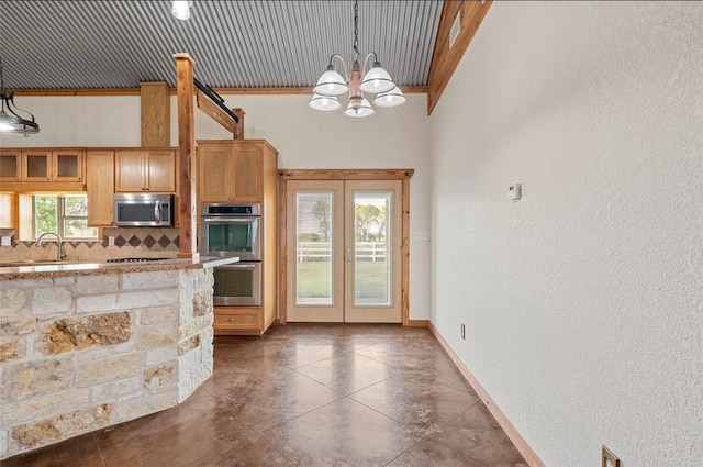 kitchen with french doors, hanging light fixtures, an inviting chandelier, backsplash, and appliances with stainless steel finishes