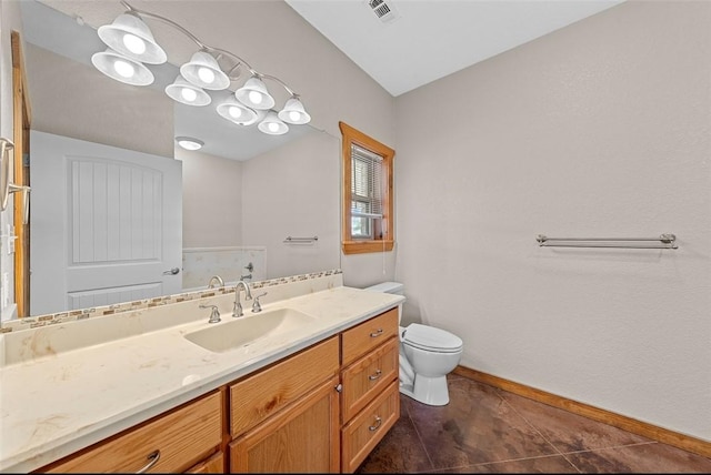 bathroom with tile patterned flooring, vanity, and toilet