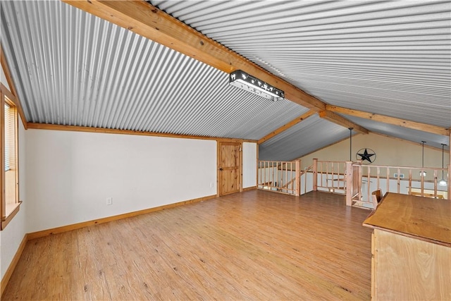 additional living space featuring wood-type flooring and lofted ceiling