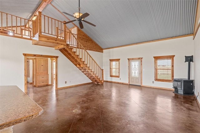 unfurnished living room featuring high vaulted ceiling, a wood stove, and ceiling fan