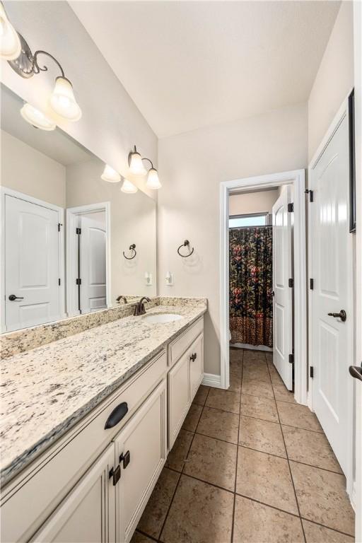 bathroom with vanity, tile patterned floors, and baseboards