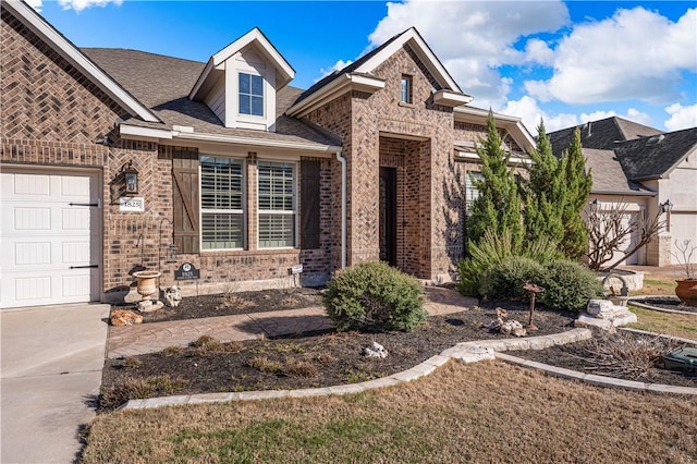 view of front of property with a garage and brick siding