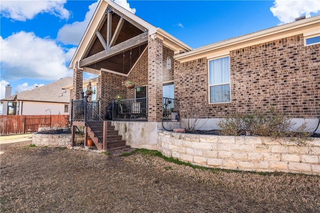 back of property featuring brick siding and fence