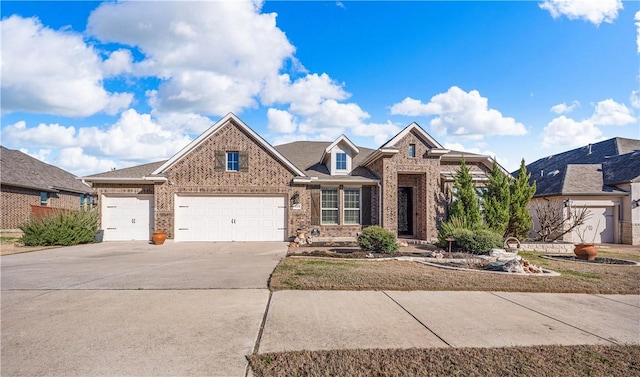 view of front of home featuring concrete driveway, a garage, and brick siding