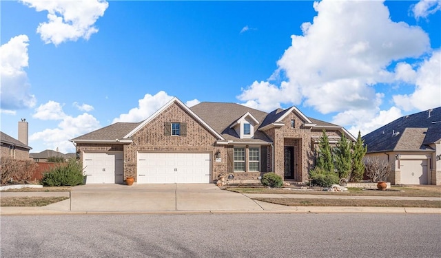 view of front of property featuring fence, brick siding, and driveway