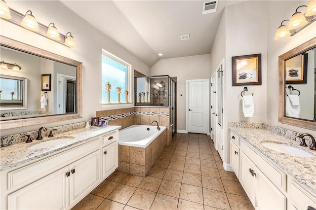 bathroom with visible vents, a shower stall, a garden tub, and a sink