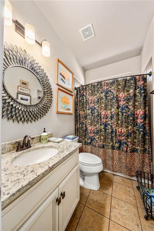 full bath featuring vanity, a shower with curtain, visible vents, tile patterned flooring, and toilet