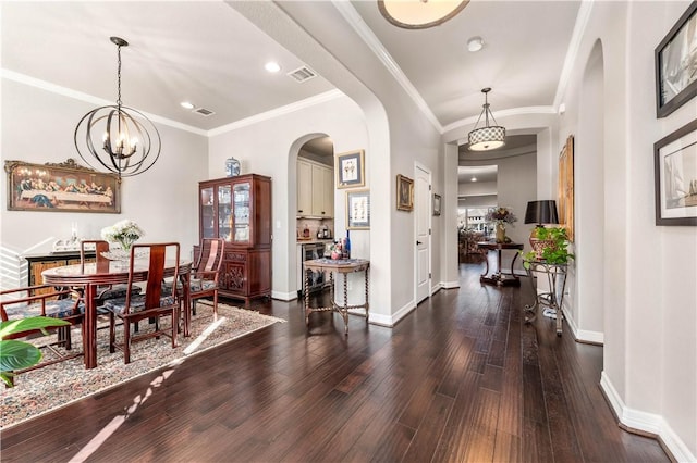 foyer entrance with visible vents, baseboards, arched walkways, and dark wood-style flooring