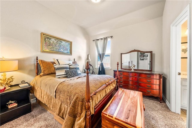 carpeted bedroom with baseboards, lofted ceiling, and ensuite bathroom