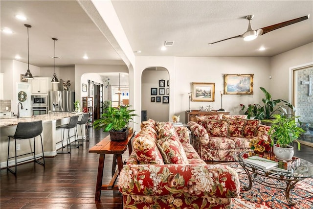 living room featuring visible vents, dark wood finished floors, recessed lighting, arched walkways, and a ceiling fan