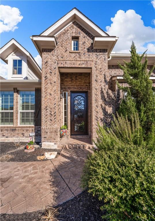 property entrance featuring brick siding