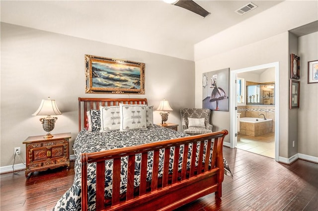 bedroom with ensuite bath, hardwood / wood-style flooring, baseboards, and visible vents