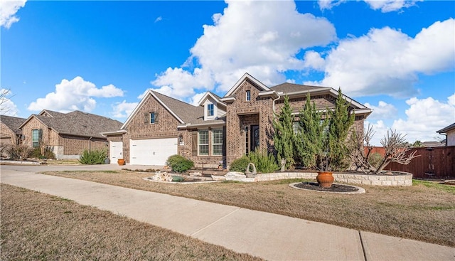 view of front facade featuring fence, driveway, a front lawn, a garage, and brick siding