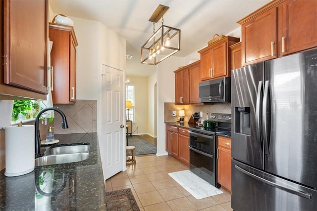 kitchen featuring stainless steel appliances, a healthy amount of sunlight, brown cabinetry, and a sink