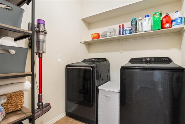 laundry area featuring laundry area, baseboards, separate washer and dryer, and light tile patterned flooring