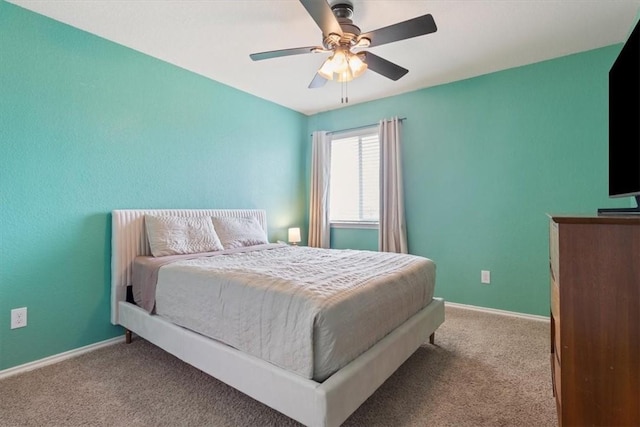 bedroom with a ceiling fan, baseboards, and carpet flooring