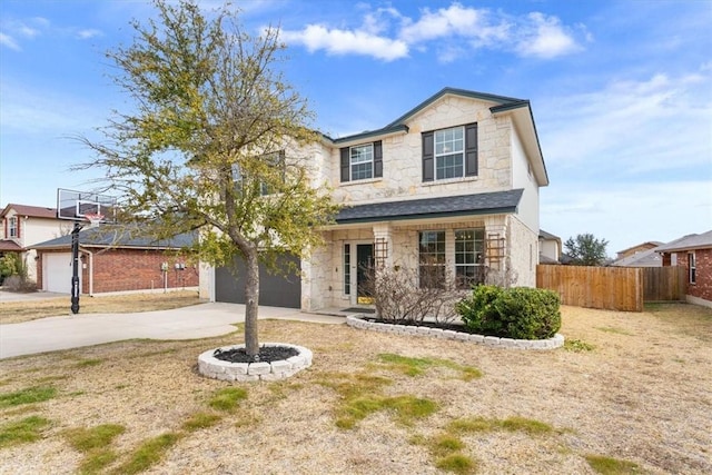 traditional home with a garage, stone siding, fence, and driveway