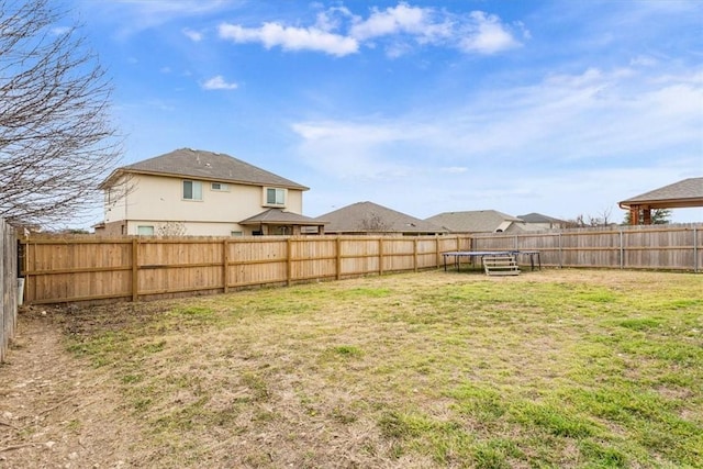 view of yard featuring a fenced backyard and a trampoline