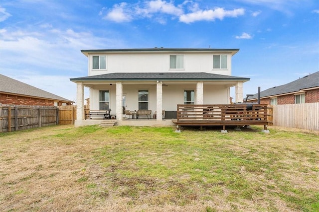 rear view of property featuring a yard, central air condition unit, a fenced backyard, and stucco siding