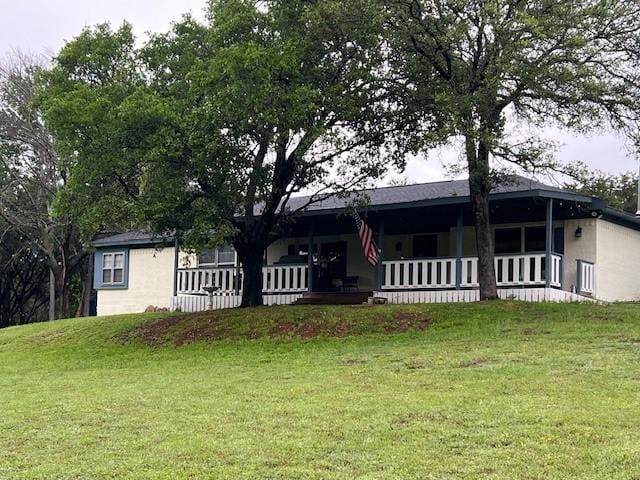 ranch-style home featuring a front yard and covered porch