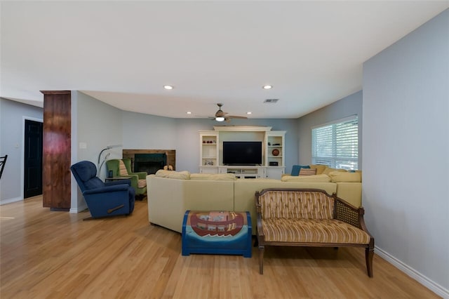 living room featuring ceiling fan and light wood-type flooring