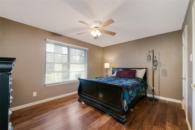 bedroom featuring ceiling fan, dark wood-type flooring, and a textured ceiling