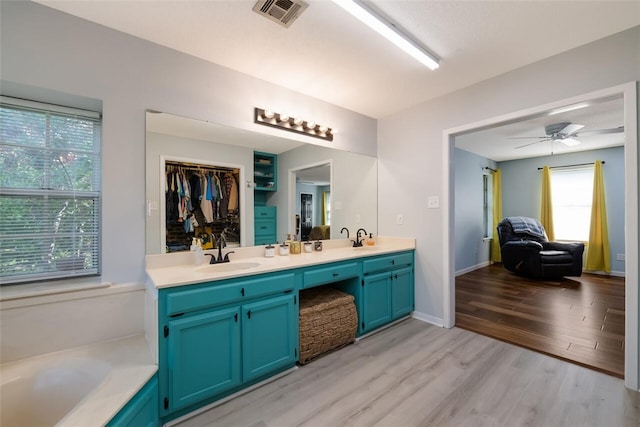 bathroom with vanity, hardwood / wood-style floors, a bathtub, and ceiling fan