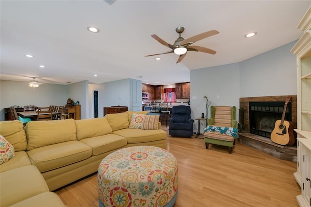 living room with ceiling fan and light hardwood / wood-style floors