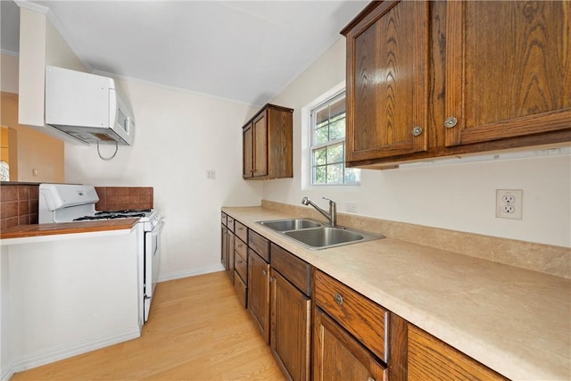 kitchen featuring light wood-type flooring, sink, and gas range gas stove